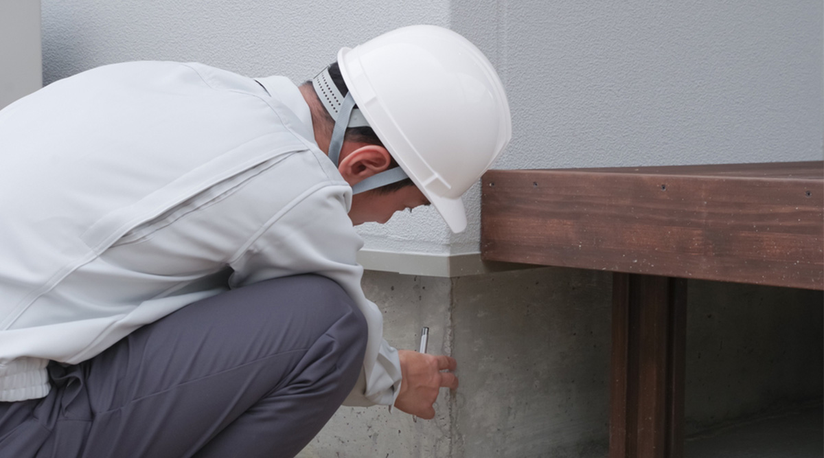 Specialist bekijkt scheur in de muur.