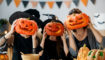 Halloween: 3 mensen met pompoenen voor hun hoofd.