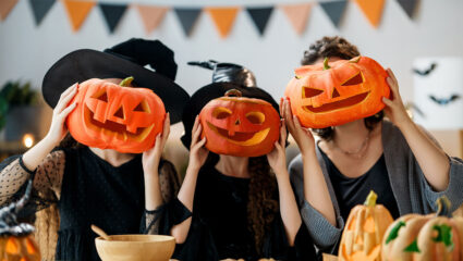 Halloween: 3 mensen met pompoenen voor hun hoofd.