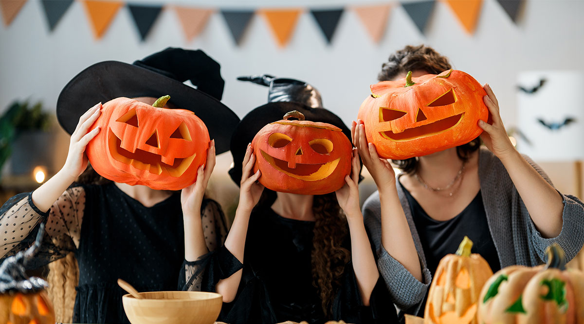 Halloween: 3 mensen met pompoenen voor hun hoofd.