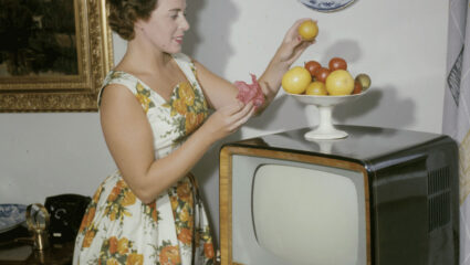 Een vrouw kijkt een televisie-uitzending op een retro tv