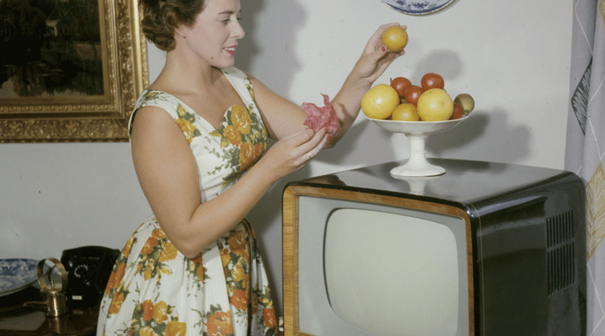Een vrouw kijkt een televisie-uitzending op een retro tv