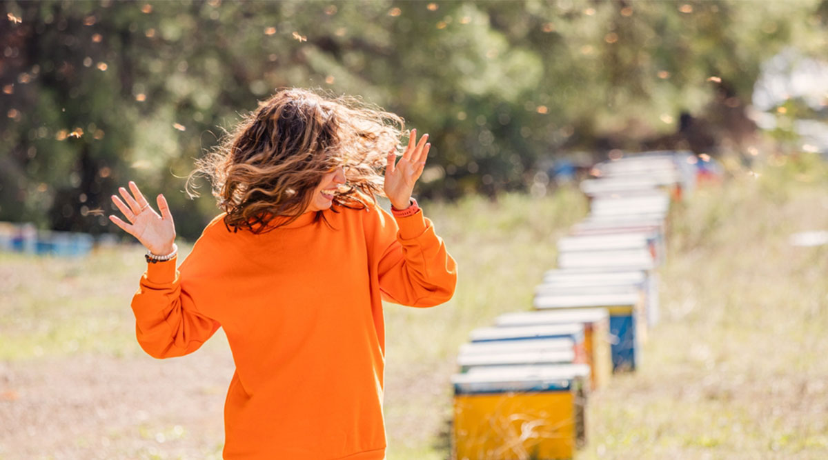 vrouw rent weg voor bijen, waardoor ze wordt aangevallen