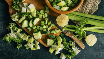 een snijplank vol met komkommer en bleekselderij