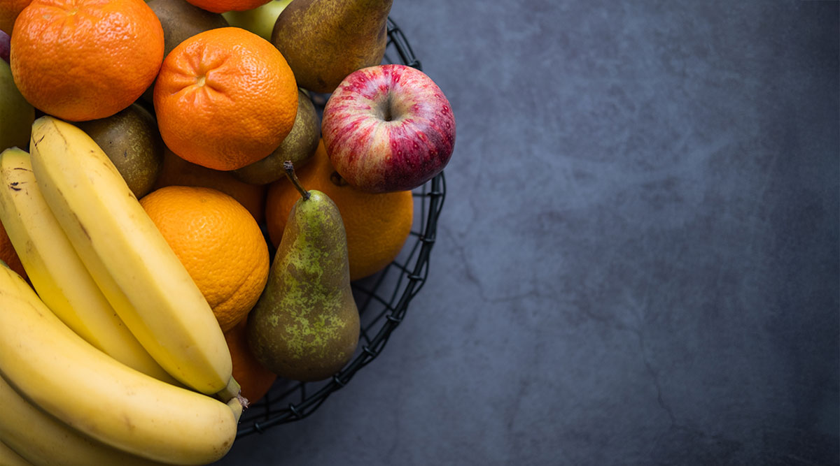 Een volle fruitschaal, met bananen, peren en mandarijnen.