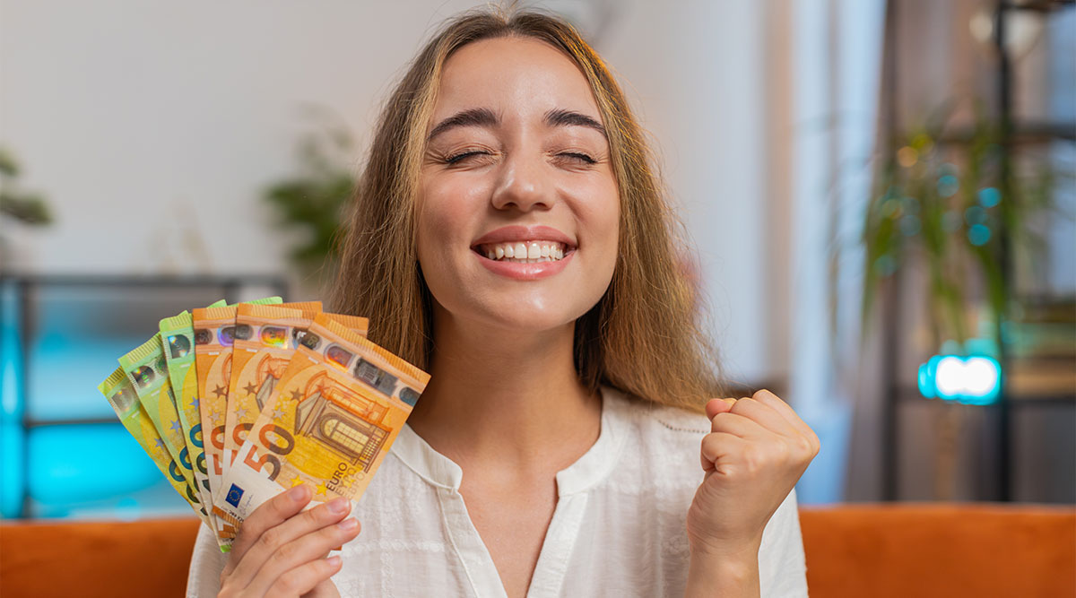 Lachende vrouw heeft bankbiljetten van 50 en 100 euro in haar hand.