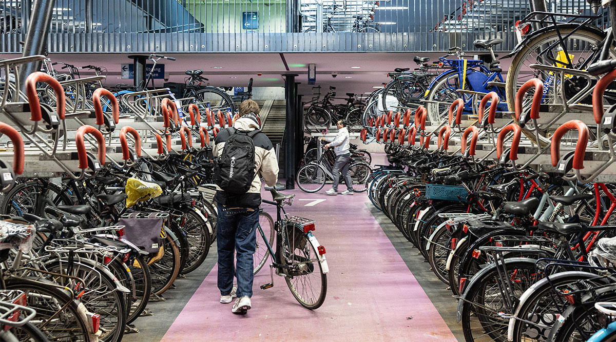 Iemand parkeert zijn fiets tussen de andere fietsen op het station