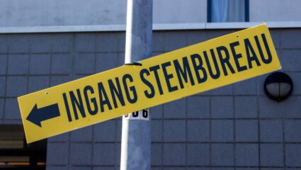 Een geel bord met de tekst: ingang stembureau.