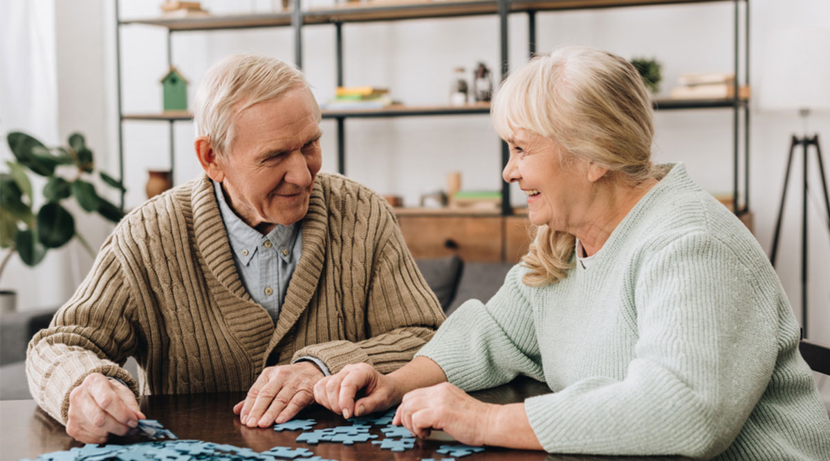 Man met dementie puzzelt met vrouw