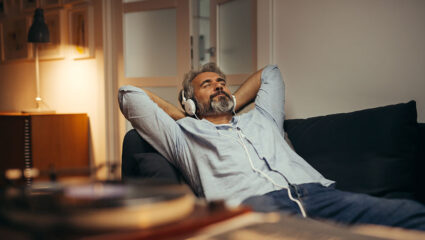 Een man luistert met koptelefoon op naar muziek, bijvoorbeeld de Klassieke Top 400.