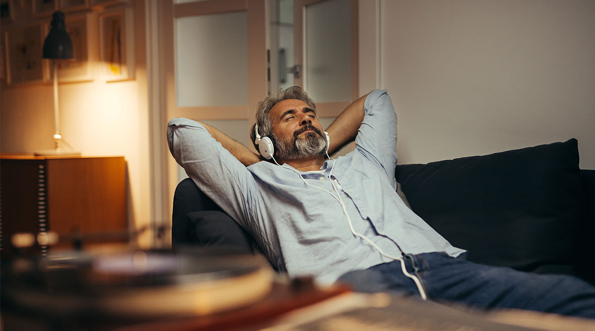 Een man luistert met koptelefoon op naar muziek, bijvoorbeeld de Klassieke Top 400.