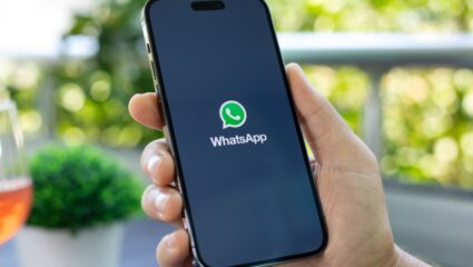 Iemand opent Whatsapp op zijn telefoon.