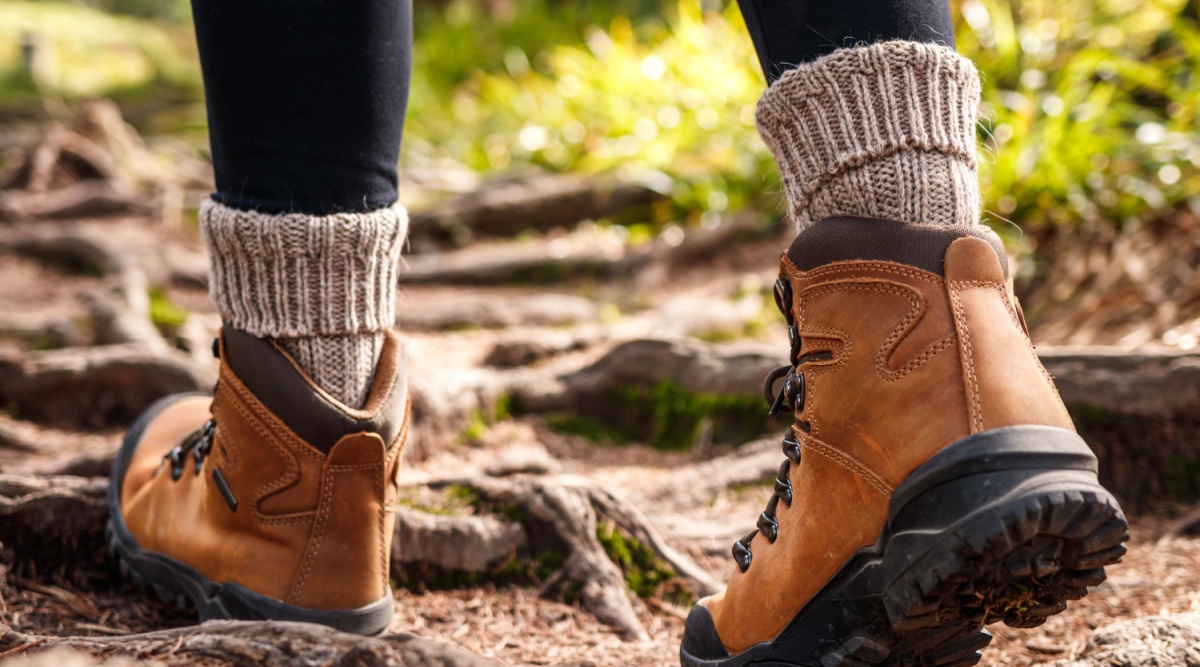 Iemand draagt hoge sokken en wandelschoenen tijdens een lange wandeling.