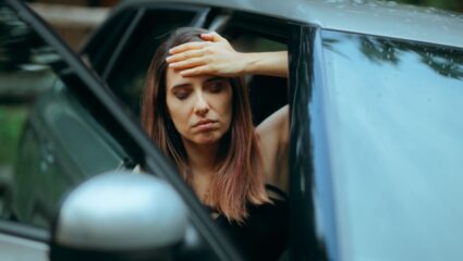 Iemand is misselijk na het rijden in een elektrische auto.