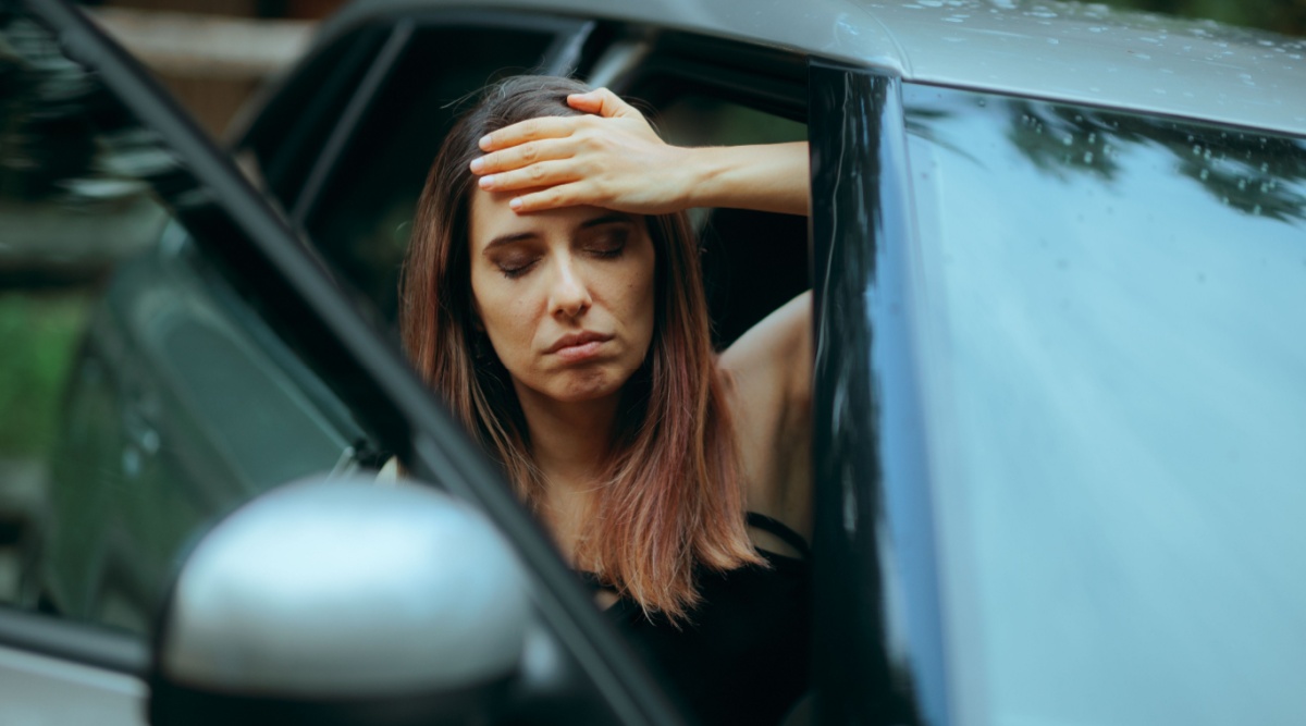 Iemand is misselijk na het rijden in een elektrische auto.