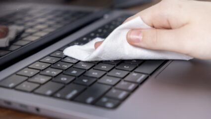 Iemand maakt haar elektronica schoon met een doek.