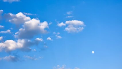 Een maan die overdag te zien is.