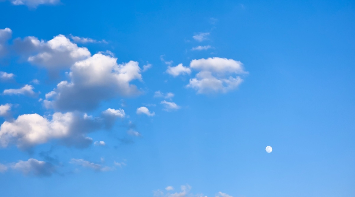 Een maan die overdag te zien is.