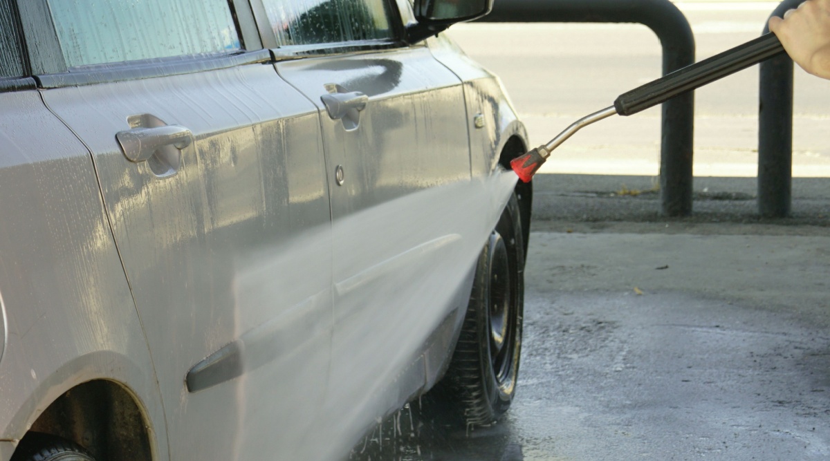 Iemand wast zijn auto in de wasstraat.