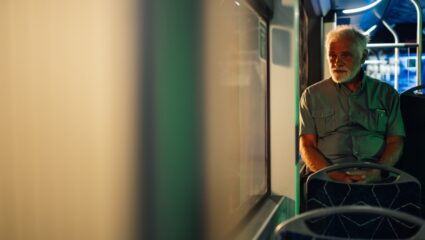 Een man zit alleen in de bus