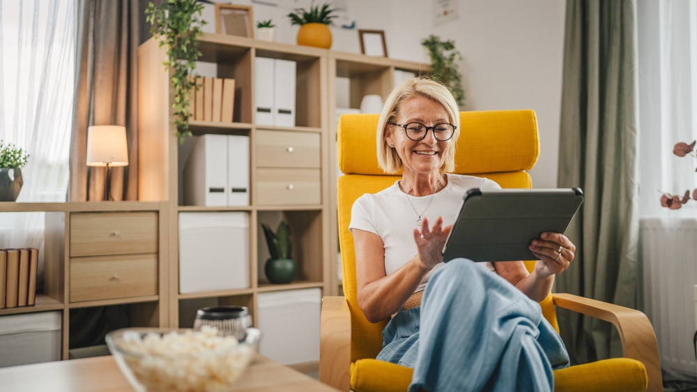 Een vrouw bekijkt de nieuwsbrieven van Omroep MAX op haar tablet