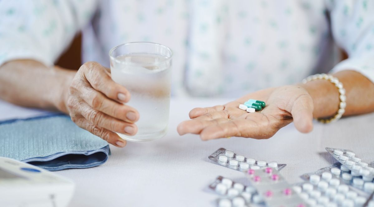 Een vrouw neemt supplementen in met een glas water in haar hand