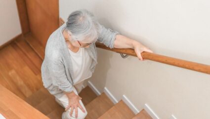 Oude vrouw loopt een trap op.