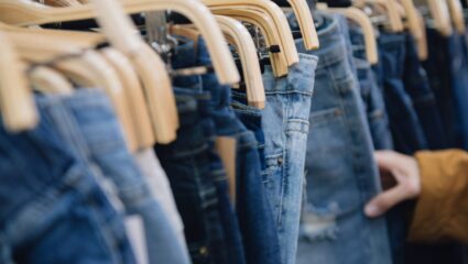 Iemand kijkt naar de maat van een spijkerbroek