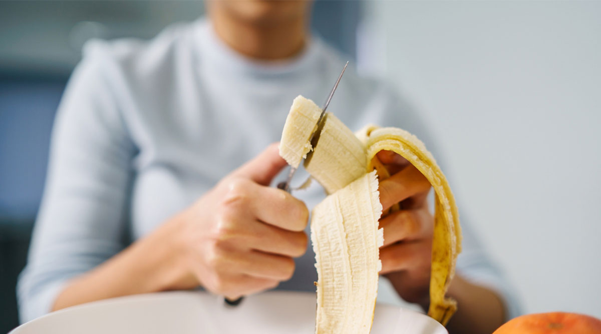 Een vrouw eet een banaan