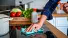 Iemand gebruikt desinfecterende middelen om het fornuis schoon te maken
