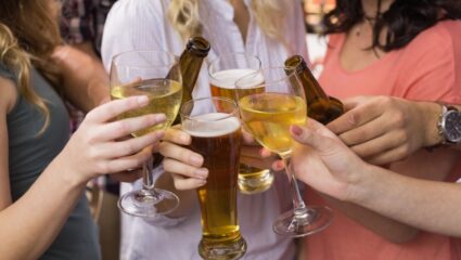 Een groep meiden proost met alcohol.