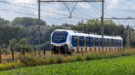 Een trein rijdt door het Nederlandse landschap