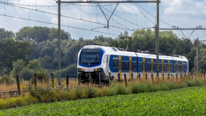 Een trein rijdt door het Nederlandse landschap