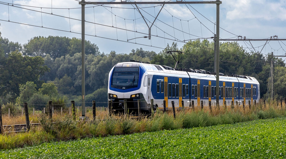 Een trein rijdt door het Nederlandse landschap