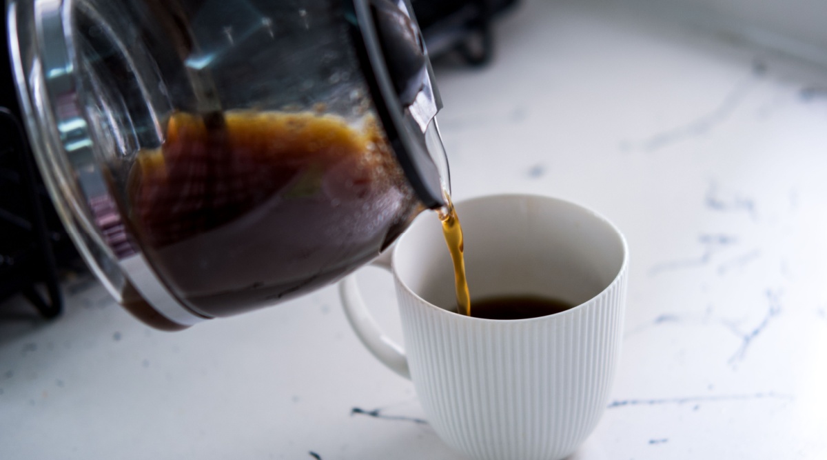 Zwarte koffie uit koffiepot in een wit kopje