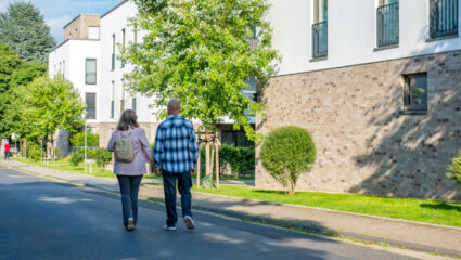 Mensen wandelen door nieuwe woonwijk na emigratie.