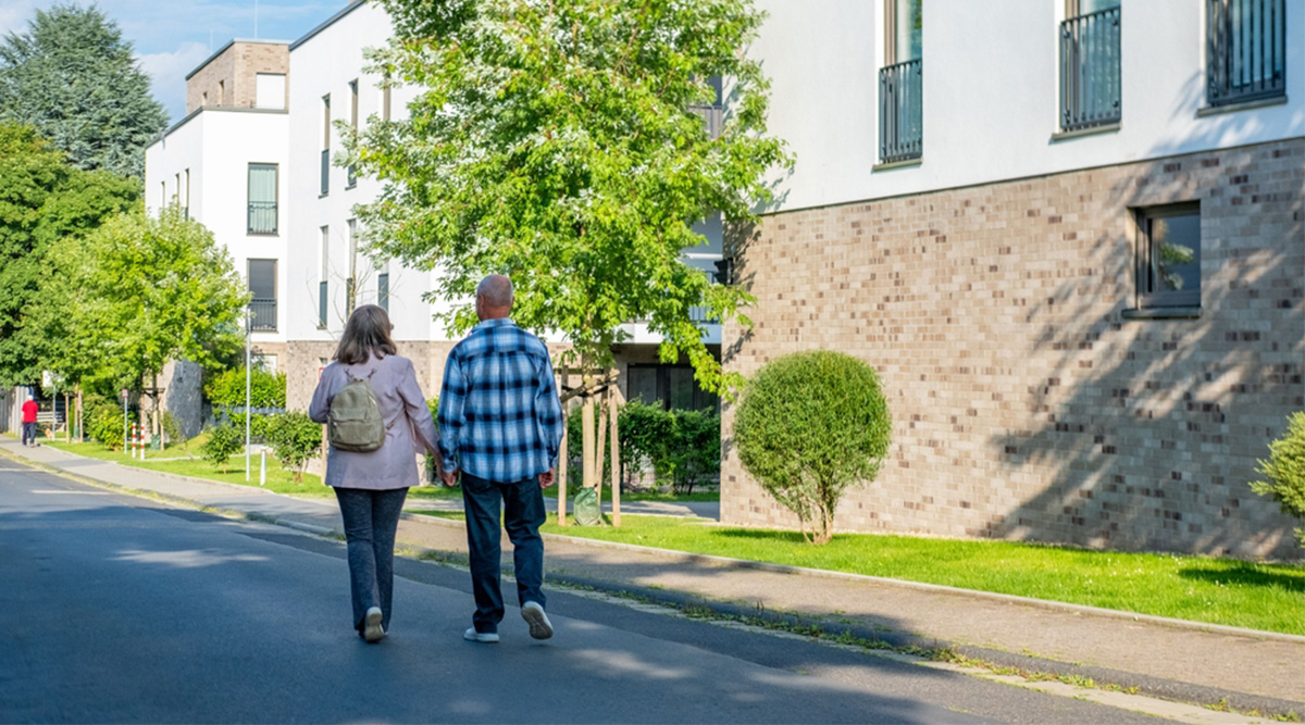 Mensen wandelen door nieuwe woonwijk na emigratie.